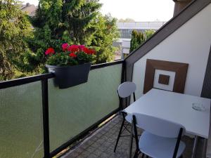 einen Balkon mit einem weißen Tisch und einem Blumentopf in der Unterkunft Ferienunterkunft - Am Stadtgarten in Saarlouis