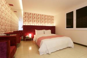 ein Schlafzimmer mit einem großen Bett und einem Fenster in der Unterkunft Q Hotel in Paju