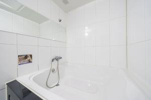 坡州的住宿－Q酒店，浴室设有带淋浴的白色浴缸。