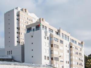 un grande edificio bianco con una croce rossa sopra di GuestReady - OceanView TopFloor w Terrace a Ponta Delgada