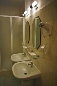 Hotel Złote Dęby في وارسو: حمام مع حوض ومرآة
