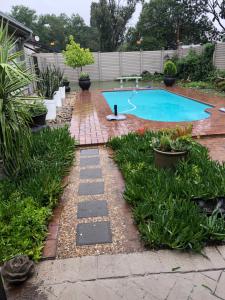 a backyard with a swimming pool and a garden at 80onBenade in Bloemfontein