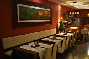 a row of tables in a restaurant with a painting on the wall at Hotel Złote Dęby in Warsaw