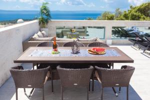 a table and chairs on a patio with a view of the ocean at Apartments Ela in Makarska