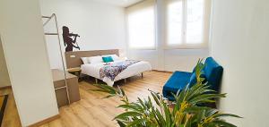 sypialnia z łóżkiem i niebieskim krzesłem w obiekcie Apartamentos Antares 2 w mieście Milladoiro