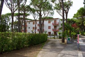 un edificio junto a una carretera con árboles en App4rent - Villa Cristina 10 - RINNOVATO, en Lido di Jesolo