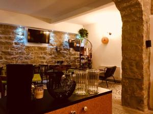 a restaurant with a counter with glasses on it at La Vecchia Posta B&B in Calangianus