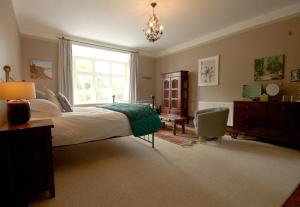 a bedroom with a large bed and a window at Costislost House in Wadebridge