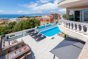 a house with a balcony with a swimming pool at Apartments Ela in Makarska