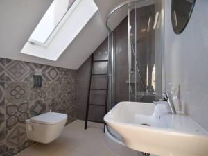 a bathroom with a sink and a toilet and a skylight at Villa Nautica in Mrzeżyno +21 photos