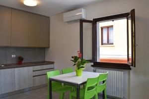 a kitchen with a table and green chairs at Residence Lake Como in Colico