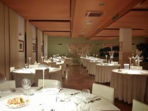 a dining room with white tables and white chairs at LOCANDA PERINELLA in Castelgomberto