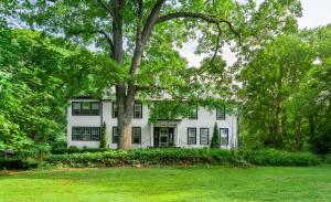 a white house with a tree in the yard at Black Mountain Inn in Black Mountain