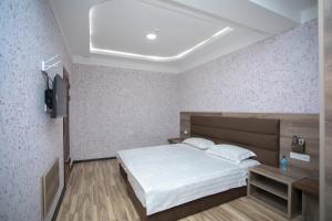 een slaapkamer met een bed en een televisie. bij Niso in Samarkand