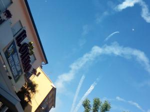 a blue sky with a building and a plane in the sky at HOTEL OTELLO in Punta Marina