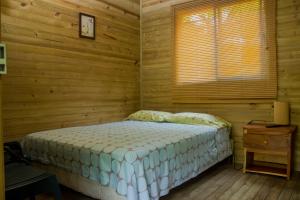Liborina的住宿－Hostería Miraflores，木制客房内的一间卧室,配有一张床