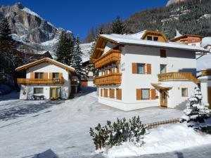 a house in the mountains with snow on the ground at La Pineta in Colfosco