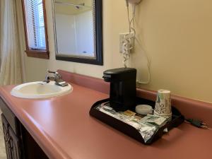 a bathroom counter with a sink and a coffee maker on it at Americas Best Value Inn Scarborough Portland in Scarborough +37 photos