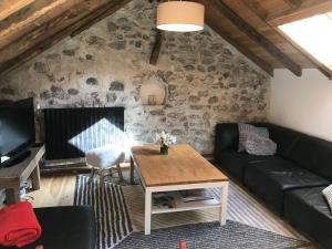 uma sala de estar com um sofá e uma mesa em Appartement Duplex avec Jardin Attenant em Briançon