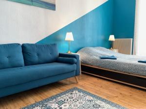een woonkamer met een bank en een bed bij 020 CHIC & COSY GRAND APPART 57m2 HYPERCENTRE WIFI SMART TV NETFLIX in Saint-Étienne