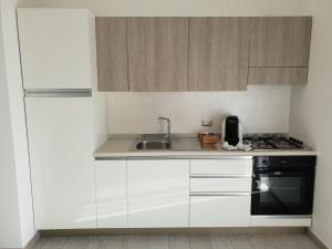 a kitchen with white cabinets and a sink and a stove at B&B Margot in Lamezia Terme