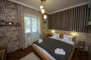 1 dormitorio con 1 cama grande y 2 toallas en Platan Garden Rooms & Restaurant, en Hajdúszoboszló