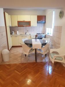 a kitchen with a table and chairs in a room at Apartments Ruzica in Makarska
