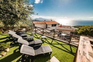 a group of chairs sitting on the grass near the ocean at Villa Bellatrix in Massa Lubrense