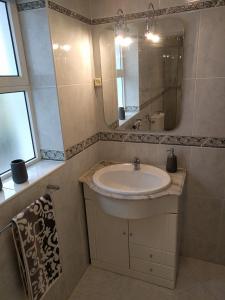 een badkamer met een wastafel en een spiegel bij Vivenda Balou in Silves