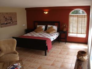 ein Schlafzimmer mit einem Bett und einem Stuhl in der Unterkunft Vivenda Balou in Silves