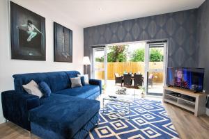 a living room with a blue couch and a tv at Rowan Tree - Your Apartment in Bristol +117 photos