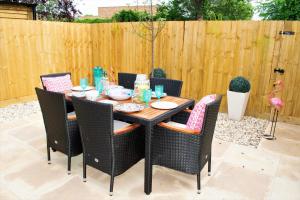 a wooden table with chairs and a wooden fence at Rowan Tree - Your Apartment in Bristol