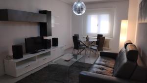 a living room with a couch and a television at Ourense Termal in Ourense