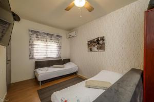 a small room with two beds and a window at SOKOLOV Vacation Boutique Apartments by the sea in nahariya in Nahariyya
