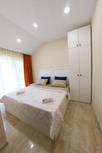 a bedroom with a large white bed and white cabinets at VIP Sweet Home in Shekvetili in Shekvetili