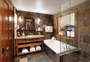 a bathroom with a sink, mirror, and bathtub at The White Buffalo Club in Jackson