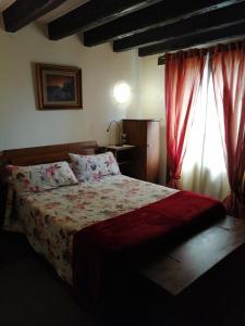 1 dormitorio con 1 cama grande y cortinas rojas en Agroturismo Iturbe, en Axpe de Busturia