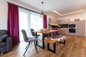 een keuken en een woonkamer met een tafel en stoelen bij ImPuls | aparts in Schladming