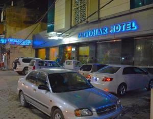 un gruppo di auto parcheggiate di fronte a un hotel di Potohar Hotel a Rawalpindi