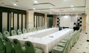 una grande sala riunioni con un lungo tavolo e sedie di Potohar Hotel a Rawalpindi
