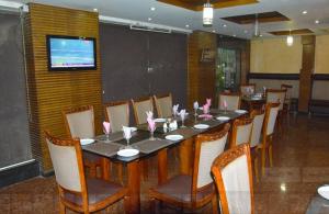 una sala da pranzo con un lungo tavolo e sedie di Potohar Hotel a Rawalpindi