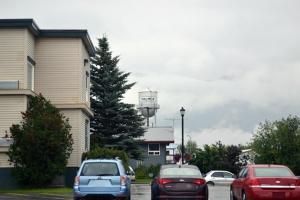 a group of cars parked in a parking lot with a water tower at Valley Hotel & 24/7 Open Cafe in Palmer