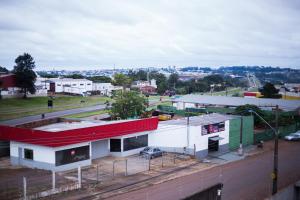 a building with a red roof on a city street at Hotel Trevo Cascavel in Cascavel