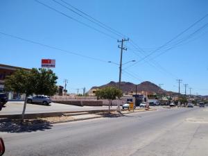 an empty street in a town with cars parked at Suites Del Sol in Guaymas