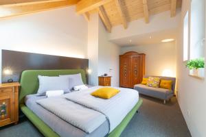a bedroom with a large bed with a green headboard at GIRBL bio APARTMENTS - Lifestyle in Strobl