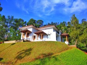 a house on top of a grassy hill at Pristine Hills in Meppādi