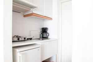 a white kitchen with a stove and a sink at Villa Von Sophia in Petriaí