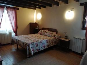 1 dormitorio con 1 cama con colcha de flores en Agroturismo Iturbe, en Axpe de Busturia