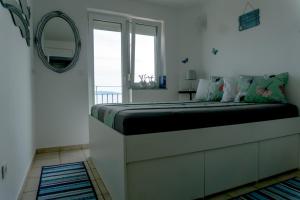 sypialnia z łóżkiem z lustrem i oknem w obiekcie Apartman ZTC w mieście Rijeka