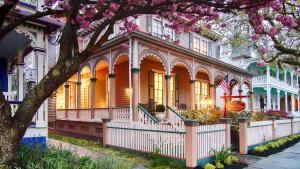 ein Haus mit einem blühenden Baum davor in der Unterkunft The Mason Cottage Downtown in Cape May